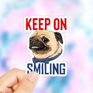 May include: A white sticker with a pug wearing a blue bow tie. The sticker says "KEEP ON SMILING" in red and blue letters.