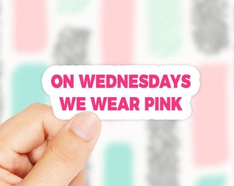 May include: A white sticker with pink text that reads "On Wednesdays We Wear Pink".