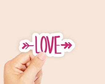 May include: A pink sticker with the word "LOVE" and arrows on either side.