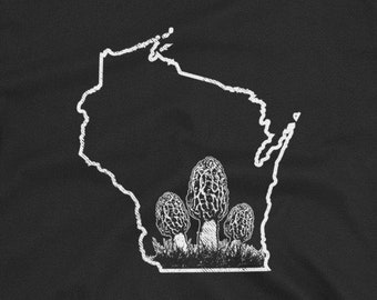Può includere: T-shirt nera con un contorno bianco dello stato del Wisconsin e una grafica di funghi spugnole. I funghi hanno cappelli e gambi strutturati, su una base erbosa, creando un design dettagliato.