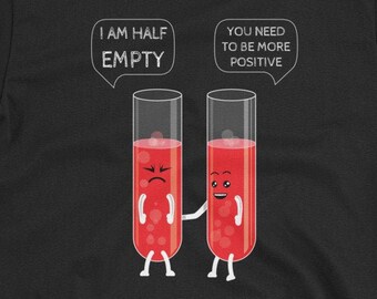 May include: Black t-shirt with a science humor graphic featuring two test tubes. One test tube is frowning and says "I am half empty". The other test tube is smiling and says "You need to be more positive".