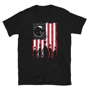 May include: Black t-shirt with a graphic of bowling pins and a bowling ball in front of an American flag.