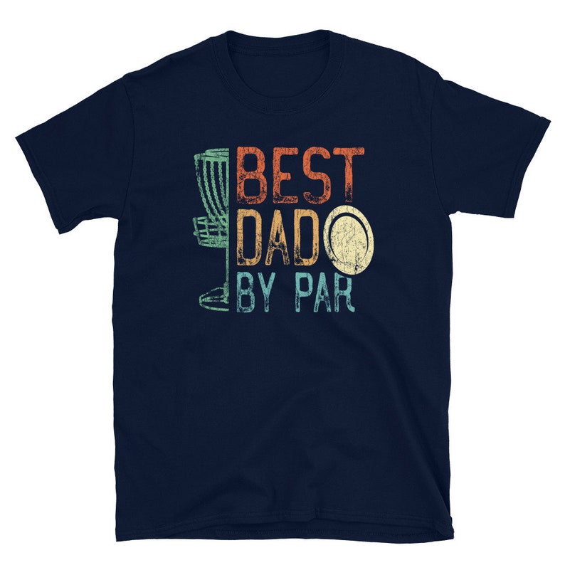 Op de afbeelding: Donkerblauw T-shirt met een vintage-stijl afbeelding van een disc golf basket en de tekst "BEST DADO BY PAR".