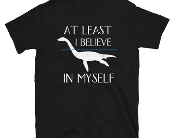 May include: Black t-shirt with a white graphic of a sea monster and the text "At Least I Believe In Myself".