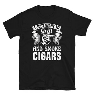 May include: Black t-shirt with white text that reads "I just want to grill and smoke cigars". The text is surrounded by a graphic of a hand holding a cigar and two grills.