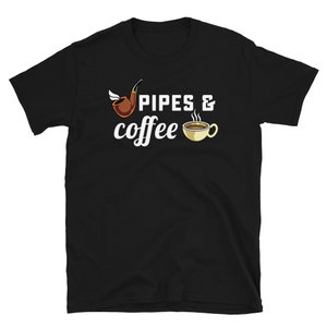 May include: Black t-shirt with the words "PIPES & coffee" in white script. The design includes a brown pipe with a wing and a cup of coffee with steam rising from it. The shirt is made of a soft material.