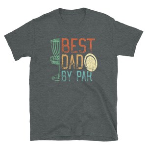Op de afbeelding: Een donkergrijs T-shirt met een vintage ontwerp met een discgolfmand, een schijf en de tekst "BEST DADO BY PAR".
