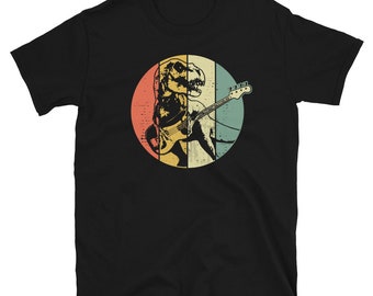 May include: Black t-shirt with a retro-style illustration of a dinosaur playing a bass guitar.