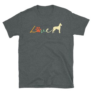 Op de afbeelding: Een donker grijs t-shirt met een retro-stijl grafische afbeelding die "Live" zegt met een pootprint en een Great Dane silhouet.