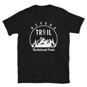 May include: Black t-shirt with a white graphic of a mountain range and a hiker. The graphic says "Nevada Trail" and "Turtlehead Peak".