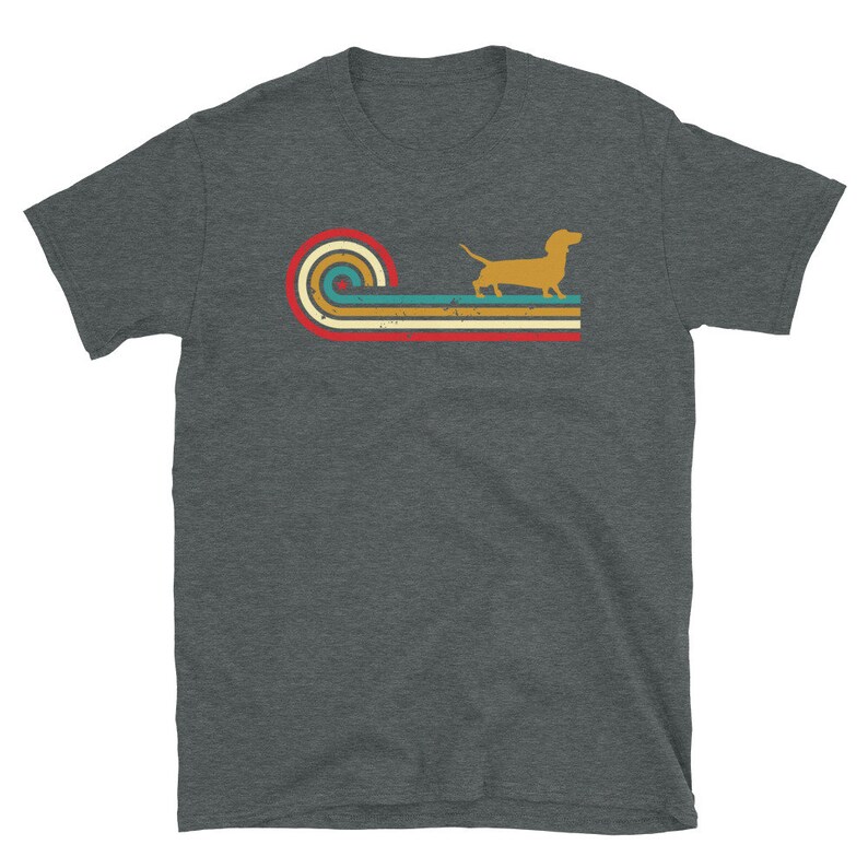 K&ouml;nnte beinhalten: Ein dunkel-melierter grauer T-Shirt mit einem Retro-Design, das eine Dackel-Silhouette vor einer mehrfarbigen gestreiften Welle zeigt.