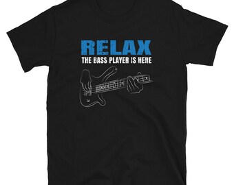 May include: Black t-shirt with white text that reads "Relax, the bass player is here". A white outline of a bass guitar is shown with a hand playing it.