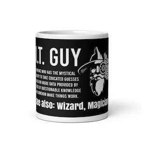 May include: White ceramic mug with a black band featuring the text "I.T. GUY" and a wizard graphic. The text describes the role of an IT professional. The mug is a standard size and has a glossy finish.