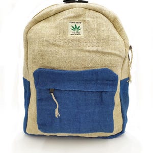 Op de afbeelding: Een henneprugzak in natuurlijk beige en blauw. De voorzak is blauw en heeft een ritssluiting. De rugzak heeft een handvat aan de bovenkant. De tekst "PURE HEMP" en "THC FREE MADE IN NEPAL" staat op de voorkant.