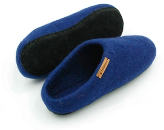 May include: A pair of blue wool slippers with a black suede insole. The slippers have a brown leather tag with the word "Feltiness" on it.