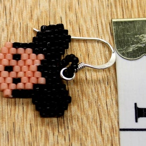 Peut inclure: Une paire de boucles d'oreilles en perles repr&eacute;sentant un Mickey Mouse en pixels. Les boucles d'oreilles sont rouges, noires, jaunes et blanches. Les boucles d'oreilles mesurent environ 2,5 cm de long et ont des crochets argent&eacute;s.