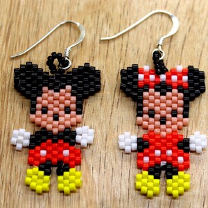 Peut inclure: Une paire de boucles d'oreilles en perles repr&eacute;sentant Mickey et Minnie Mouse. Les boucles d'oreilles sont faites de perles noires, blanches, rouges et jaunes. Les boucles d'oreilles sont suspendues &agrave; des crochets argent&eacute;s.
