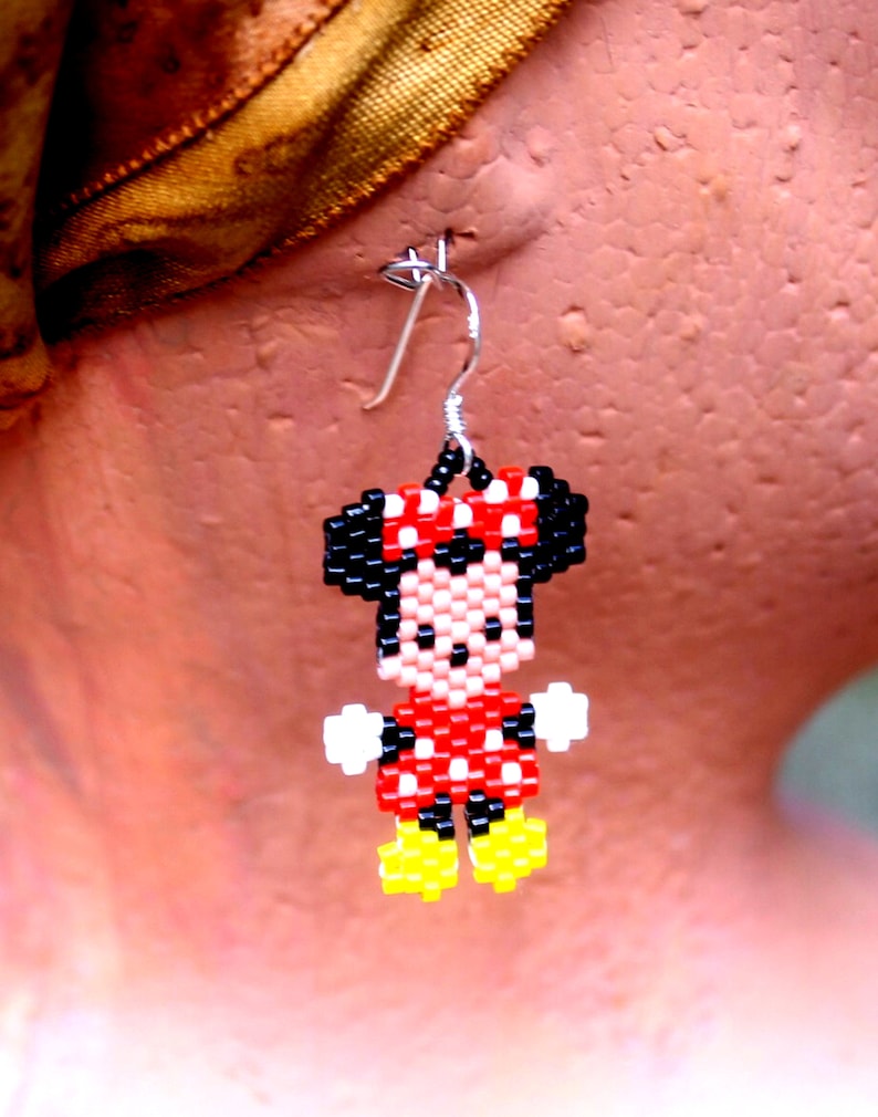 Peut inclure: Une paire de boucles d'oreilles en perles repr&eacute;sentant un personnage de dessin anim&eacute; avec une robe rouge, des chaussures noires et un n&oelig;ud noir. Le personnage est une souris de dessin anim&eacute; populaire.