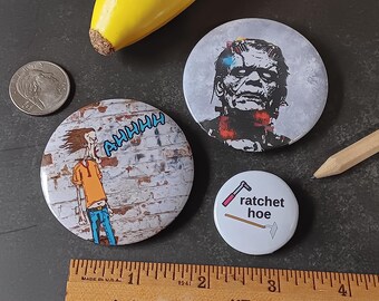 3 Piece Monster Attitude Novelty Pin Set - 3 Pinback Buttons: Graphic Frankenstein, Mad Man Screaming at a Brick Wall, Ratchet Hoe (tools)