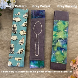 May include: Three fabric spoon holders with different patterns. The first is a light blue fabric with a white pattern of cartoon animals. The second is a dark grey fabric with a white embroidered spoon design. The third is a green and blue fabric with a white watercolour pattern. The text "Single Pattern", "Grey Pocket", and "Grey Backing" is above each holder.
