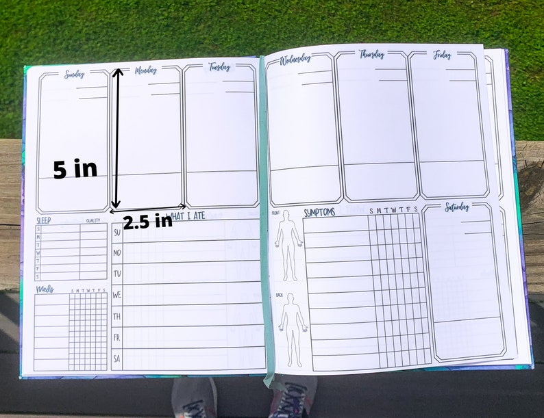 May include: A weekly planner with sections for sleep, what you ate, symptoms, and a daily log. The planner is open to show the daily log section, which is divided into seven columns for each day of the week. The planner measures 5 inches tall and 2.5 inches wide.