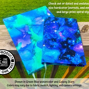 May include: Two hardcover journals with different covers. One journal has a blue and green watercolor design. The other journal has a galaxy print with blue, purple, and white stars. The journals are on a wooden surface. The text "This product plants one tree" is on a black circle sticker.