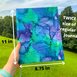 May include: A large, blue and green journal with a marbled cover. It measures 11 inches tall and 8.75 inches wide. The text on the journal reads "TWICE the size of the regular size journal!"