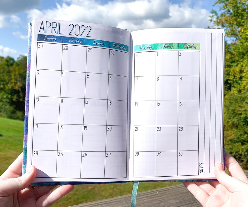 May include: A monthly planner with a white background and black grid lines. The month is April 2022. The days of the week are labeled at the top of the page. The planner has a section for notes on the right side.