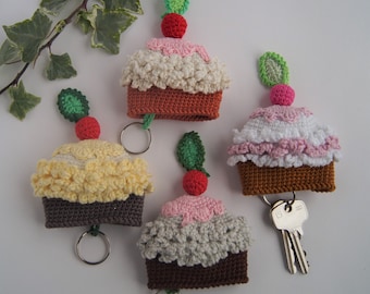 May include: Four crocheted cupcake keychains with different colored frosting and cherries. Each keychain has a metal ring.
