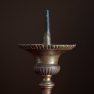 Puede incluir: Un candelero de lat&oacute;n vintage con una base acanalada decorativa y un solo portavelas.