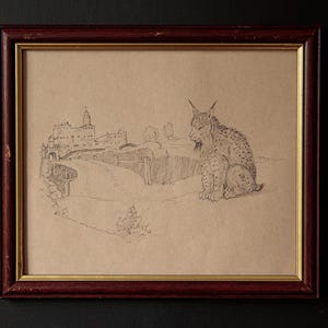 May include: Pencil sketch of a lynx sitting in front of a landscape with a building and bridge, framed in a dark red wooden frame with a gold inner border. The artwork is on tan paper.