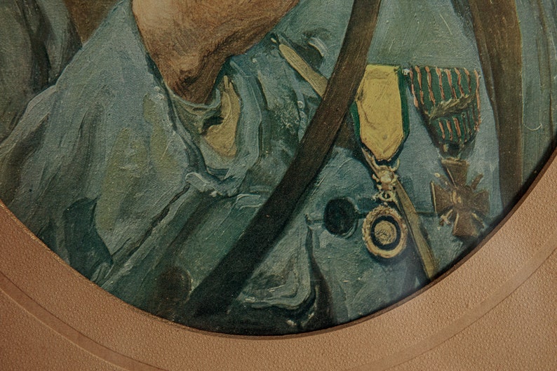 Pode incluir: Close-up de um uniforme militar com uma medalha verde e dourada e uma correia marrom. O uniforme &eacute; azul escuro e a medalha tem uma fita vermelha e branca.