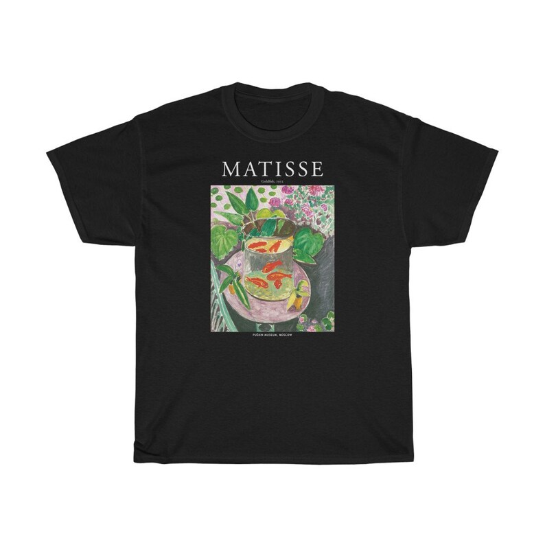 May include: Black t-shirt with a print of a painting by Henri Matisse titled "Goldfish and a Bowl of Flowers". The painting depicts a bowl of goldfish on a table with flowers and leaves.