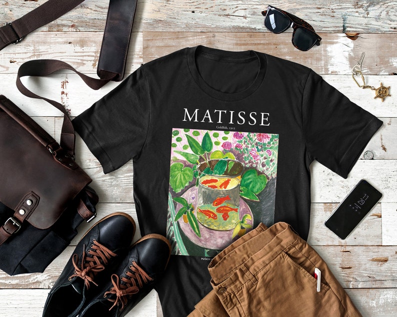 May include: Black t-shirt with a colorful painting of goldfish in a bowl by Henri Matisse. The painting is titled "Goldfish, 1912".