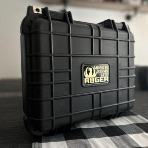 May include: Black hard-sided case with a gold label that reads "Mark IV 22/45 Lite Ruger".