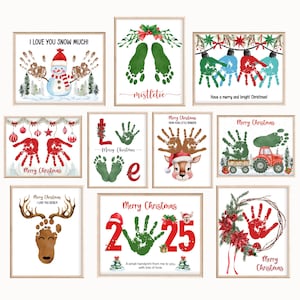 May include: A selection of framed Christmas art prints. The prints showcase handprints and footprints in diverse colours, creating festive images such as snowmen, reindeer, and Christmas trees. Text includes holiday greetings and the phrase "I love you snow much!"