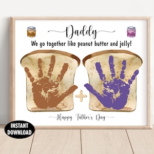 May include: A framed print featuring the text Daddy, We go together like peanut butter and jelly!, and Happy Father's Day. It displays two slices of bread with brown and purple handprints, small jars of peanut butter and jelly, and a plus sign.