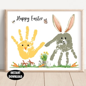 May include: A framed print with a light wood frame featuring a handprint chick and bunny. The words "Happy Easter" are written at the top. Carrots, flowers, and a watering can are at the bottom. The words "INSTANT DOWNLOAD" are at the bottom.