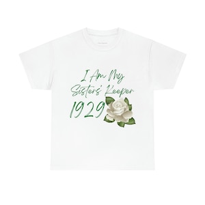 Könnte beinhalten: Weißes T-Shirt mit dem Text "I Am My Sister's Keeper 1929" in grüner Schrift. Unter dem Text ist eine weiße Rose mit grünen Blättern abgebildet. Das T-Shirt hat einen Rundhalsausschnitt.