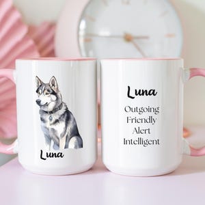 May include: Two white ceramic mugs with pink rims. One mug features a watercolor illustration of a gray and white husky dog with the name "Luna" printed below. The other mug has the name "Luna" printed in black with the words "Outgoing, Friendly, Alert, Intelligent" printed below.