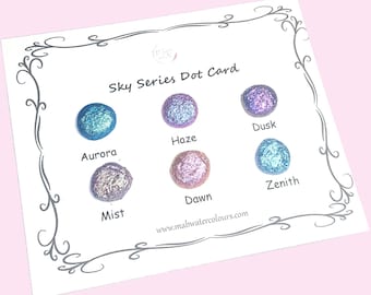 May include: A white card with a decorative border displays six colorful watercolor paint dots labeled "Aurora," "Haze," "Dusk," "Mist," "Dawn," and "Zenith." The card is titled "Sky Series Dot Card" and includes the website mabwatercolours.com.