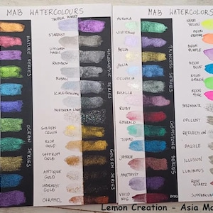 May include: A close-up of a watercolor paint swatch chart with 48 different colors. The chart is divided into four sections: Nature Series, Ocean Series, Holographic Series, and Gemstone Series. Each section has a different color scheme. The chart is labeled "MAB Watercolors" at the top.