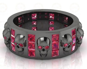 May include: Black ring with a row of skull designs and red gemstones.