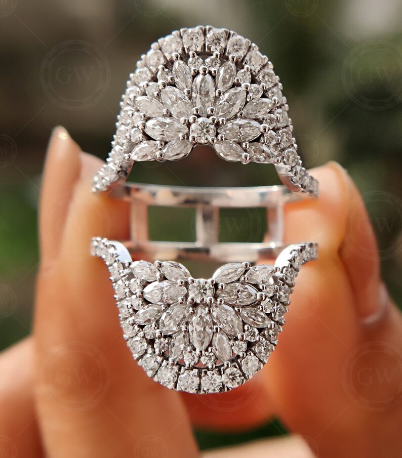 May include: A silver ring with a large, intricate design of small, clear diamonds. The ring is made up of two pieces that fit together.