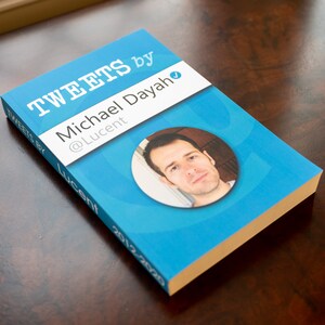 May include: A blue book titled "Tweets by Michael Dayah @Lucent" with a photo of the author on the cover.