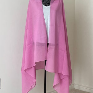 May include: A pink sheer scarf draped over a mannequin. The scarf is made of a lightweight fabric and has a soft, flowing drape.