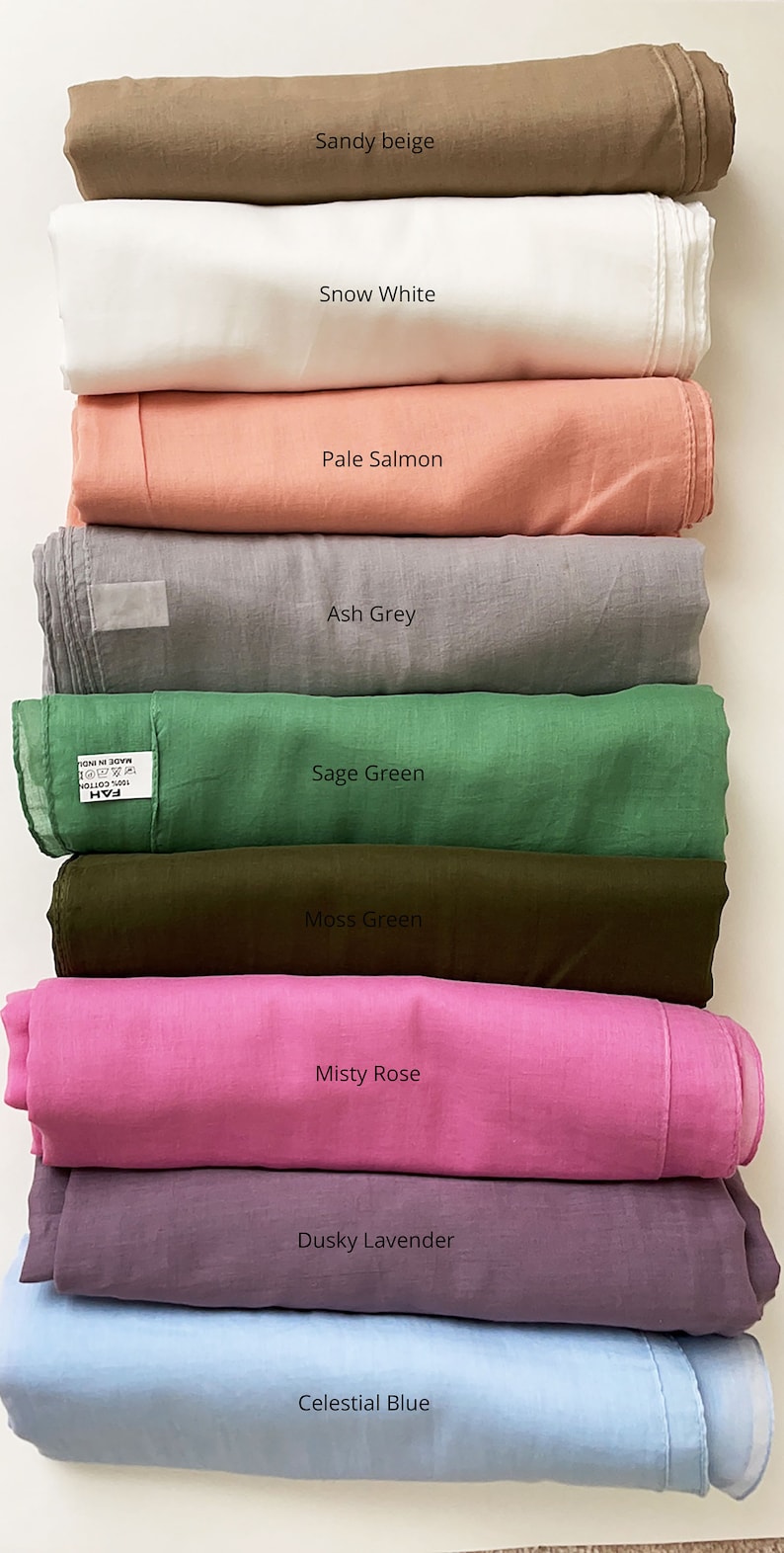 May include: A stack of ten fabric swatches in various colors, including sandy beige, snow white, pale salmon, ash grey, sage green, moss green, misty rose, dusky lavender, and celestial blue.