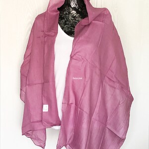 May include: A soft, sheer, onion pink scarf draped over a white shirt on a mannequin.