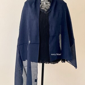May include: A navy blue scarf with a subtle pattern. The scarf is draped over a mannequin.