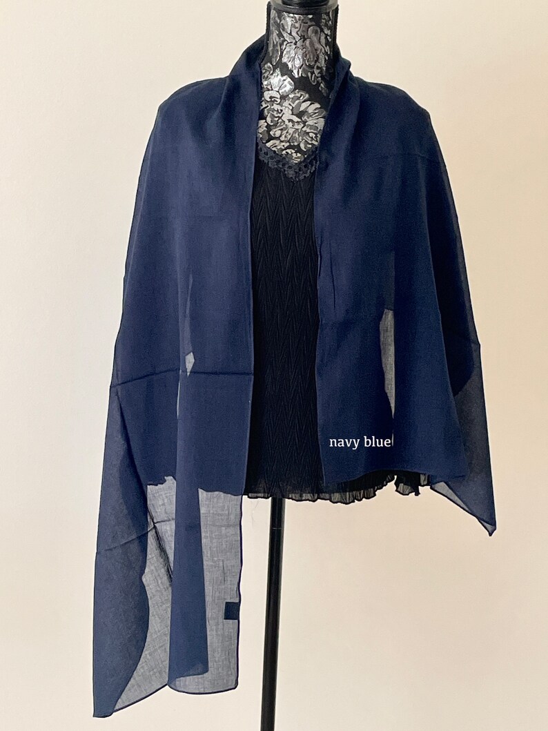 May include: A navy blue scarf with a subtle pattern. The scarf is draped over a mannequin.